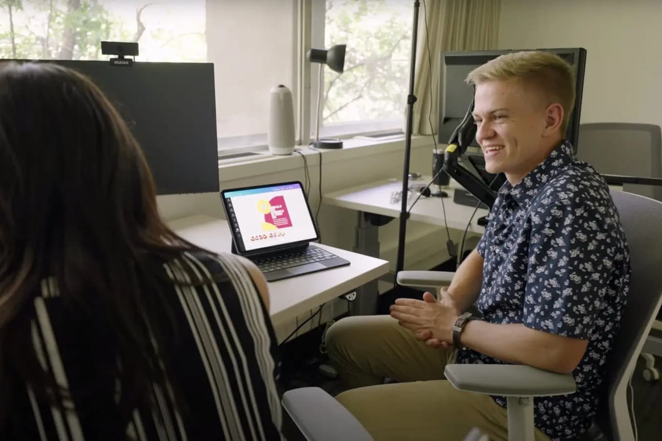 Two people talking in front of a computor
