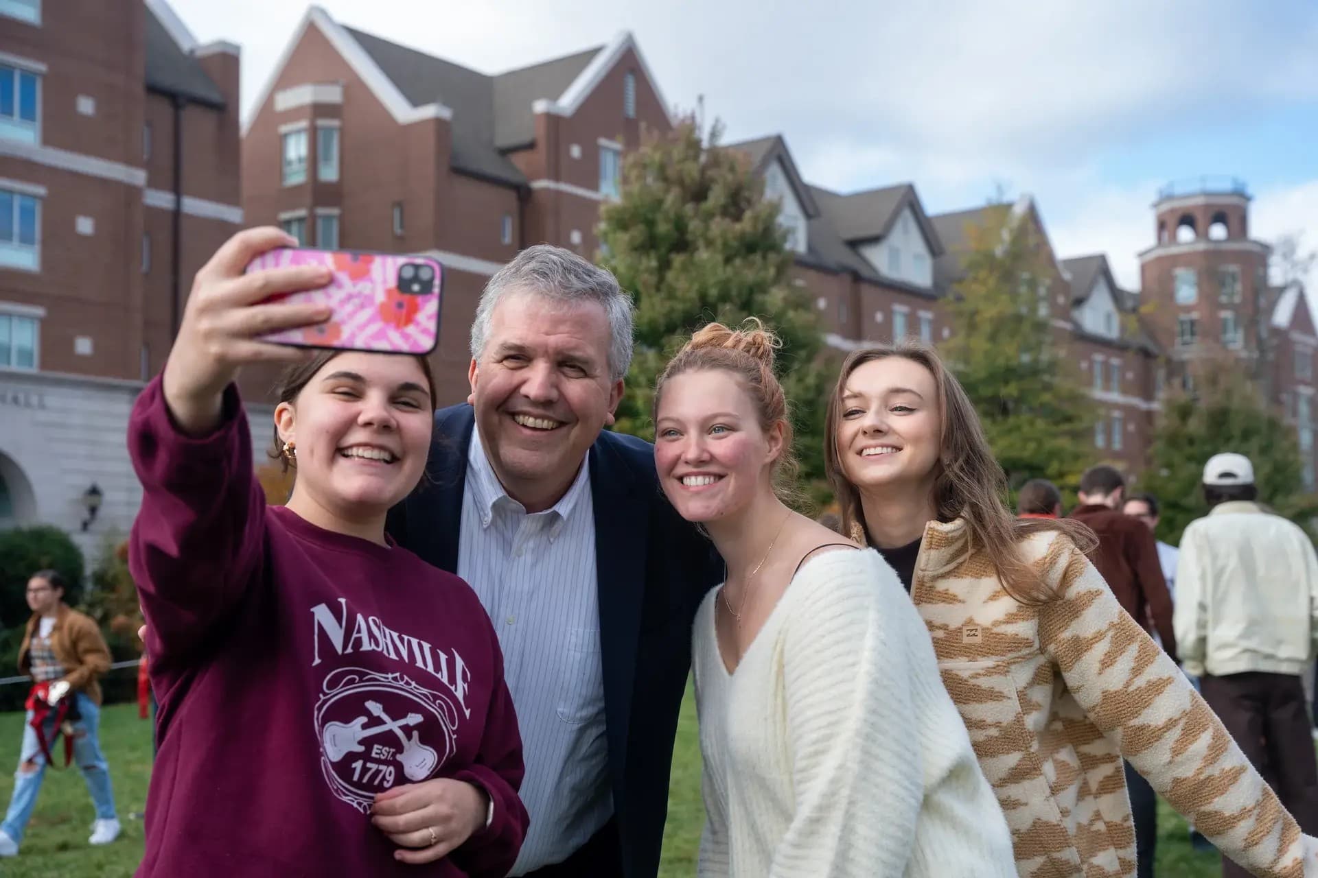 Family taking a selfie outside of a university